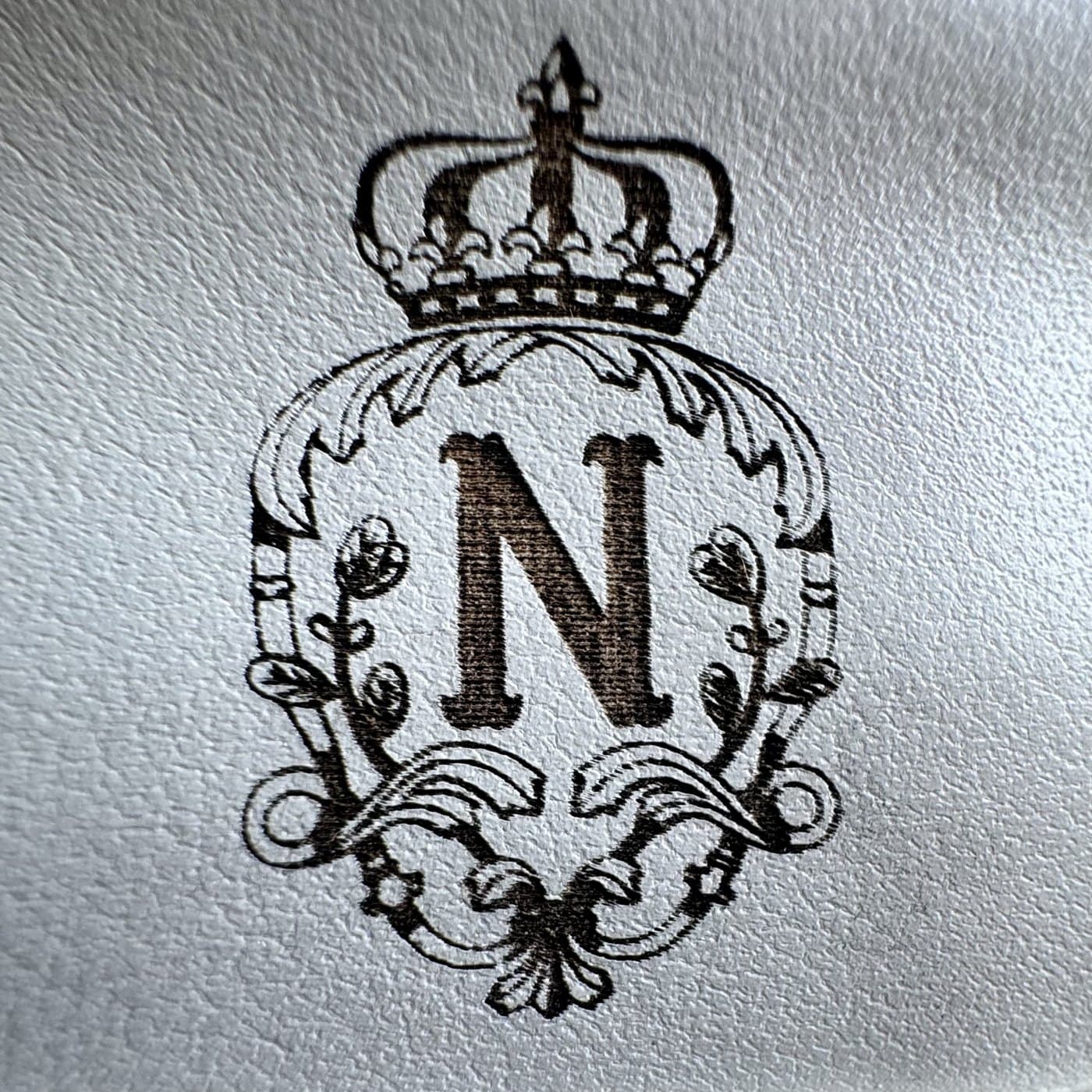 Detail d'une gravure laser fine dans le cuir : le faisceau marque la matiere elle-meme, a 0,1 mm de precision
